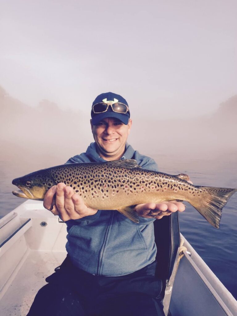 A Man holding a brown trout